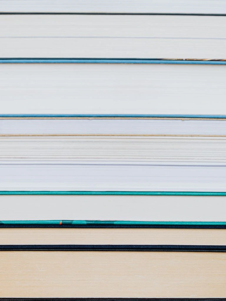 Stack of bound research reports and lifecycle study on a drafting table